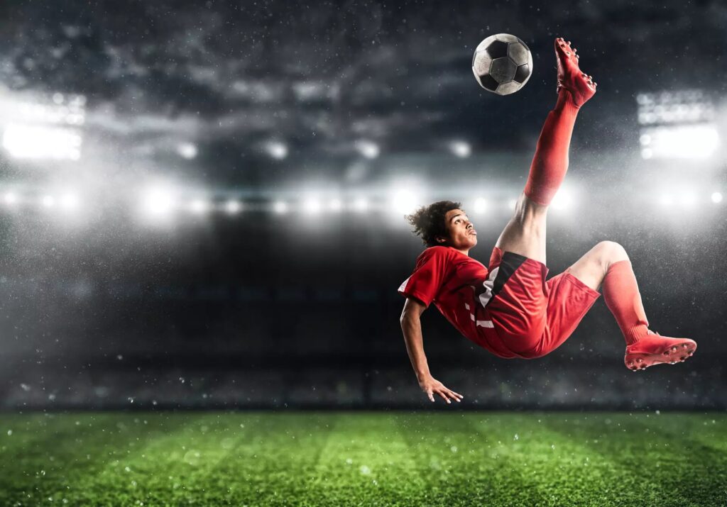 soccer striker red uniform hits ball with acrobatic kick air stadium